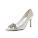 White high-heeled shoe with a decorative crystal embellishment on a white background