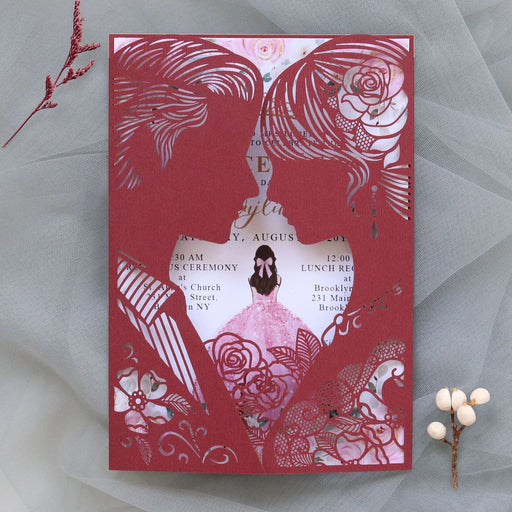 Decorative wedding invitation with intricate cut-out designs on a gray background