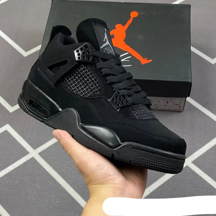 Black sneaker held in hand with Jordan box in the background
