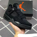 Black sneaker held in hand with Jordan box in the background