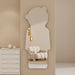 A modern full-length wall mirror with a bear silhouette cutout, styled in a minimalist beige room next to a white sideboard.