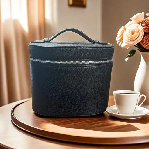Black leather travel case on a wooden table with a cup of coffee and flowers in the background