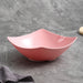 Pink ceramic bowl with measurements on a gray background