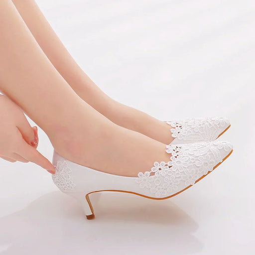 White lace high heels being worn on a light background