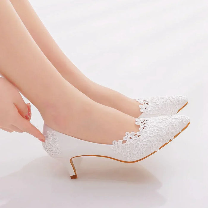 White lace high heels being worn on a light background