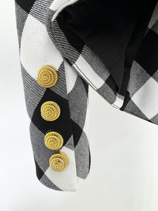 Close-up of a black and white checkered fabric with gold buttons on a white background