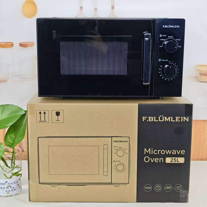 A black F. Blümlein microwave oven sits on top of its brown cardboard packaging box in a kitchen setting.
