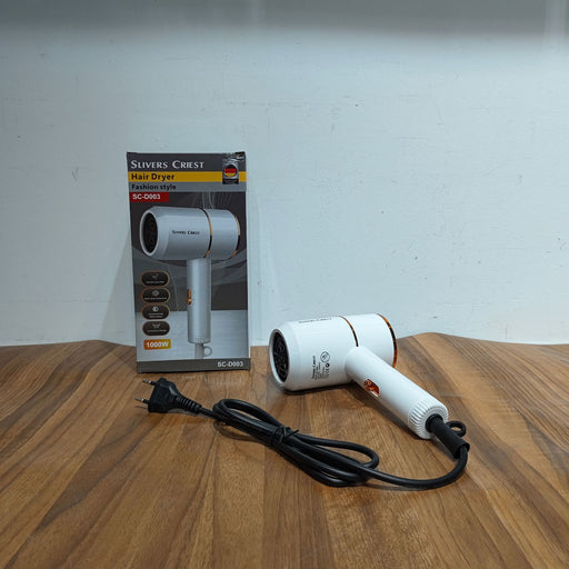 White hair dryer with packaging on a wooden surface