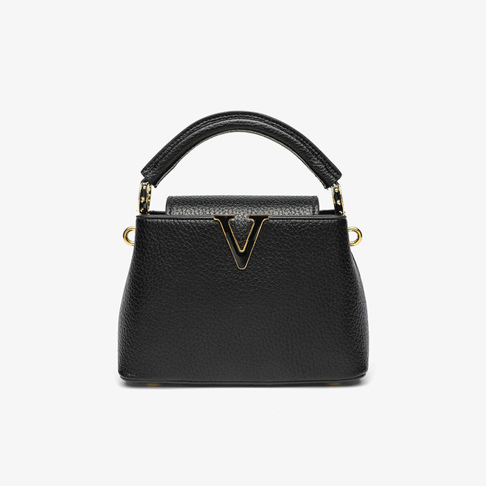 Black handbag with gold accents on a white background
