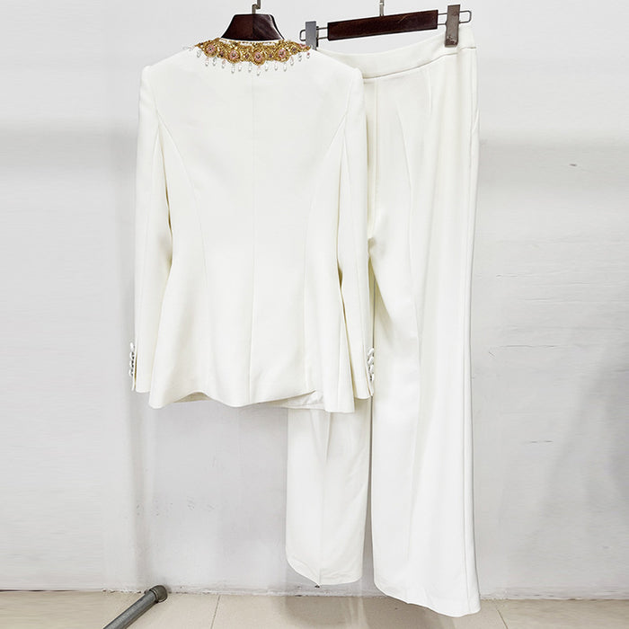 White outfit with gold embellishments on a hanger against a white background