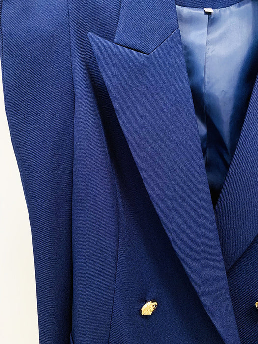 Close-up of a blue suit jacket with a gold button on a white background
