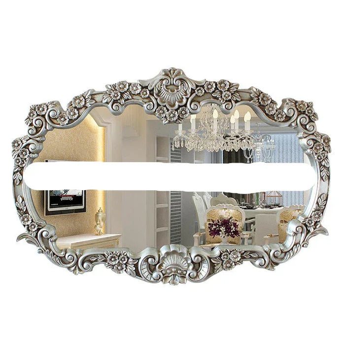 Decorative wall mirror with intricate floral frame on a white background