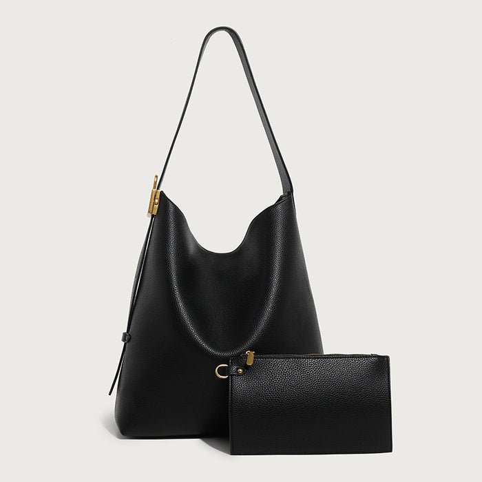 Black handbag with matching wallet on a light gray background
