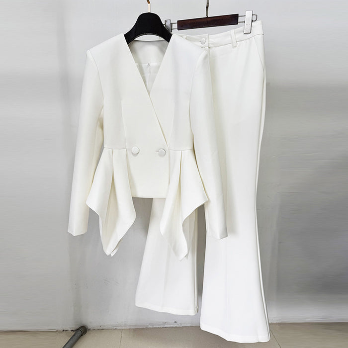 White suit jacket and pants on hangers against a plain background