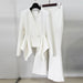 White suit jacket and pants on hangers against a plain background