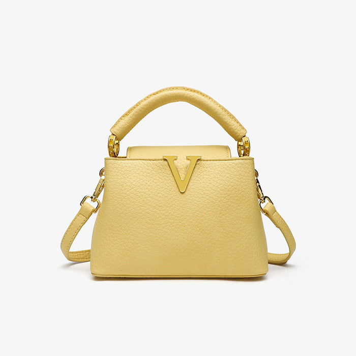 Yellow handbag with a gold handle and clasp on a white background