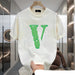 White t-shirt with green logo held in a modern interior setting
