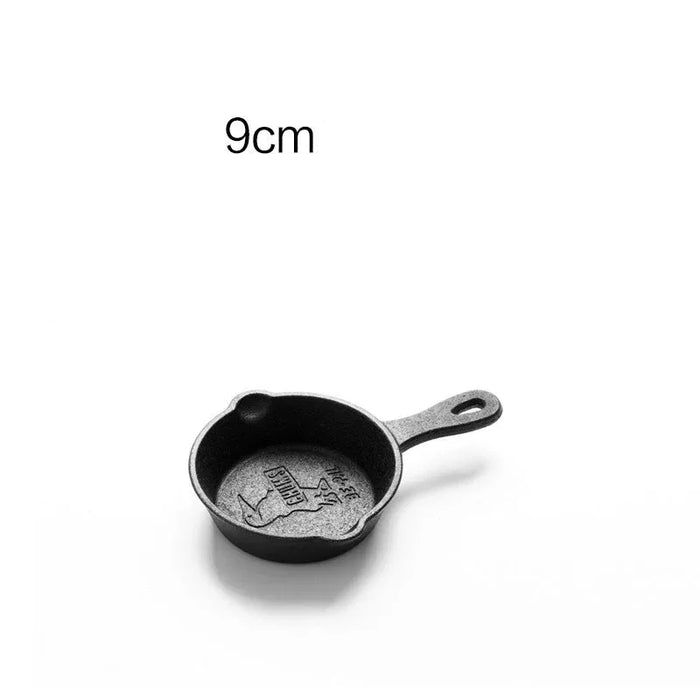 Small black cast iron skillet with handle on a white background