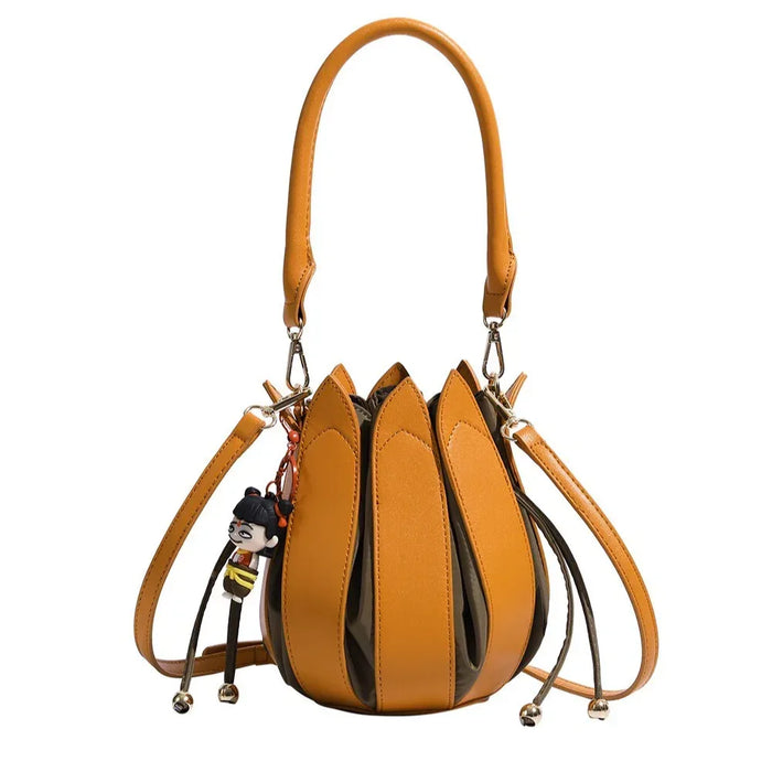 Brown handbag with decorative straps and a keychain on a white background