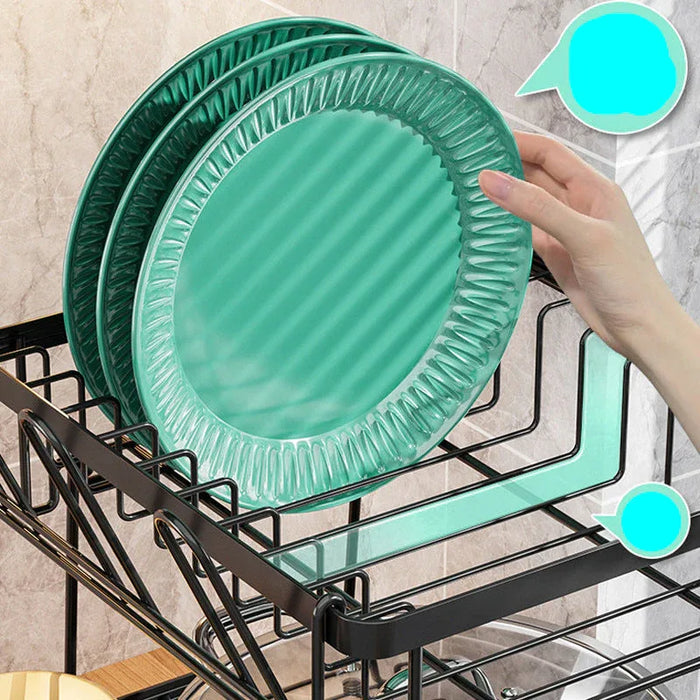 Green ceramic plates on a dish rack with a hand placing one plate on top.