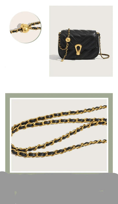 Black handbag with gold chain strap on a light gray background