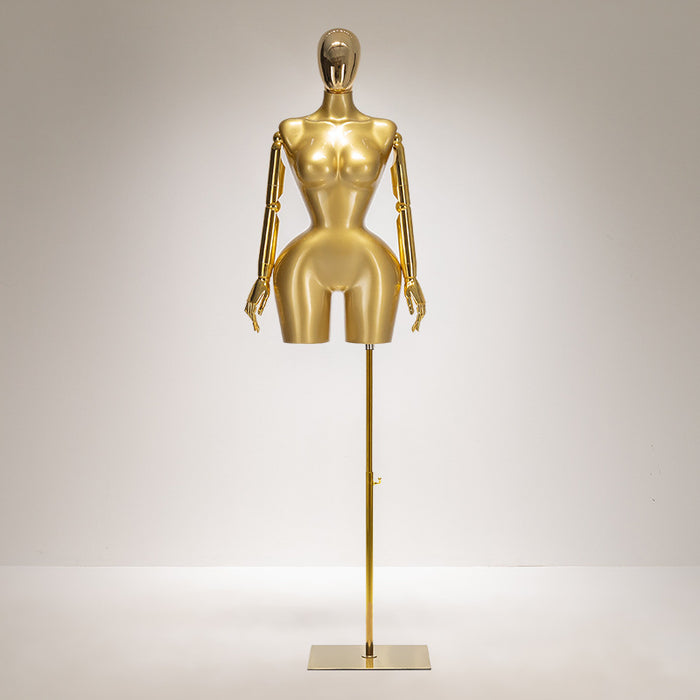 Gold mannequin on a stand against a gray background