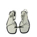 White sandals with metallic accents on a white background