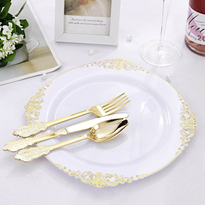 Gold cutlery set on a decorative white plate with a blurred background