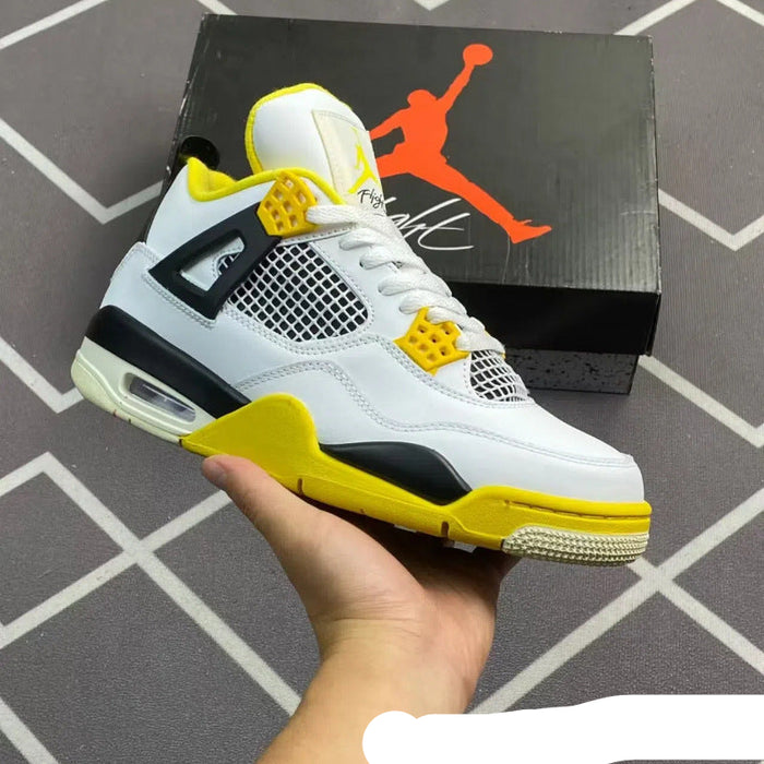 White and yellow sneaker held in a hand with Jordan brand box in the background
