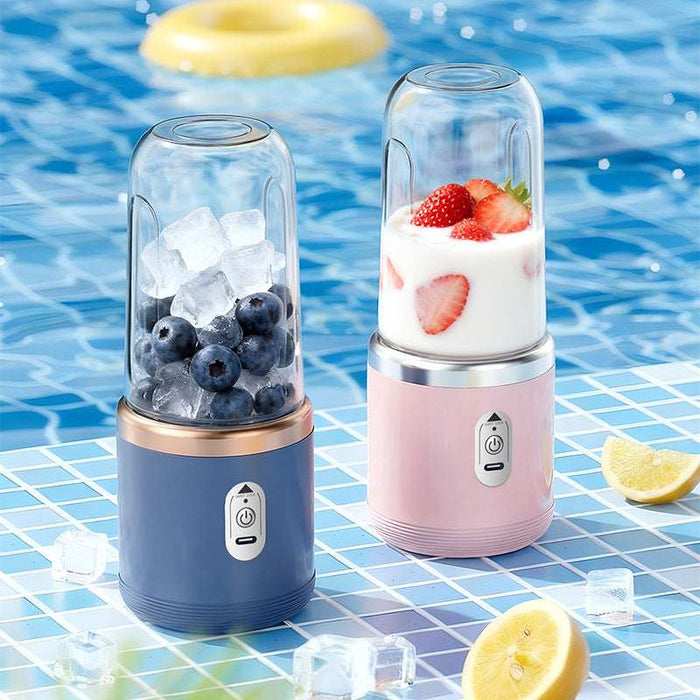 Two portable blenders with ingredients on a poolside table.
