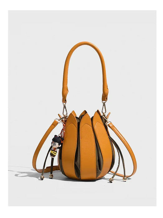 Yellow handbag with decorative elements on a light gray background