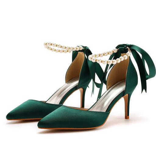 Green high-heeled shoes with pearl embellishments on a white background
