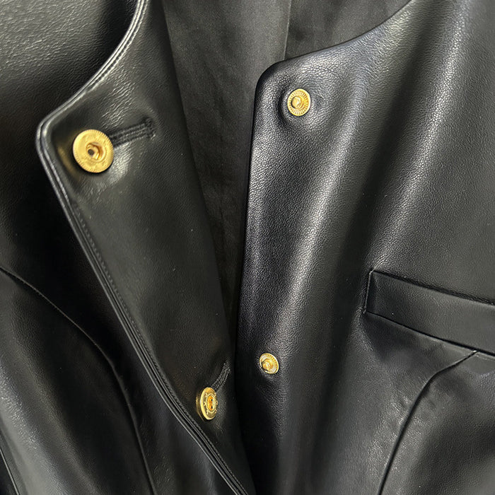 Close-up of a black leather jacket with gold buttons