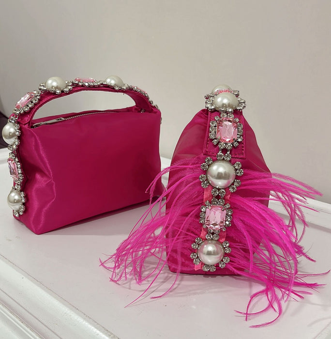 Two pink handbags with decorative elements on a white surface