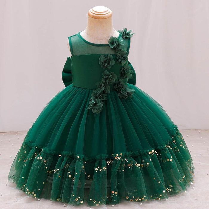 Green children's dress with floral details on a mannequin against a plain background