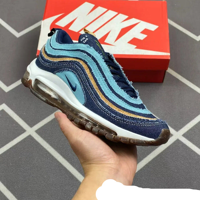 Blue and brown sneaker held in a hand with a red Nike box in the background