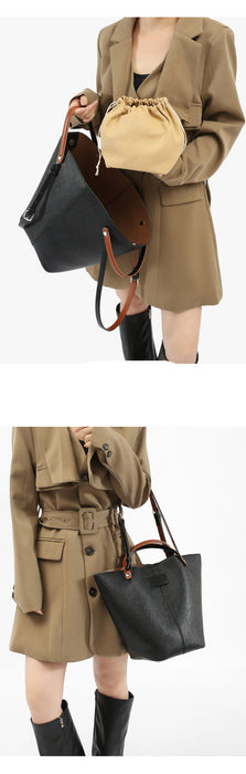 Person holding a black handbag with a beige coat and skirt set on a white background