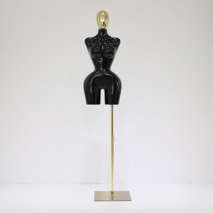 Black mannequin torso on a gold stand against a white background