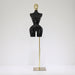 Black mannequin torso on a gold stand against a white background