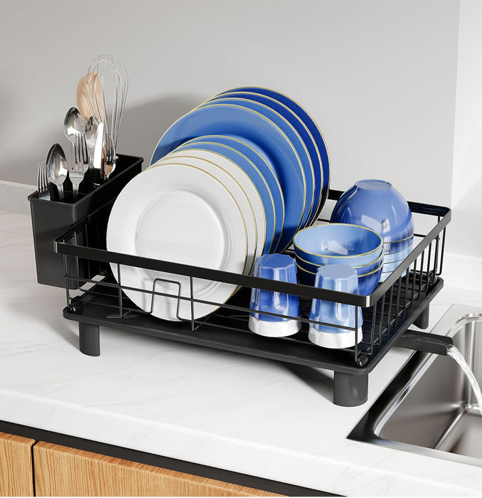Black dish rack with blue and white dishes on a kitchen counter.