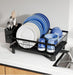 Black dish rack with blue and white dishes on a kitchen counter.