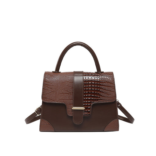 A brown handbag with a mix of textured faux-crocodile and smooth leather panels, featuring a top handle, a front strap closure with a gold-tone buckle, and a detachable shoulder strap, shown against a plain white background.