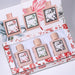 Set of four perfume bottles with floral designs in a decorative box.