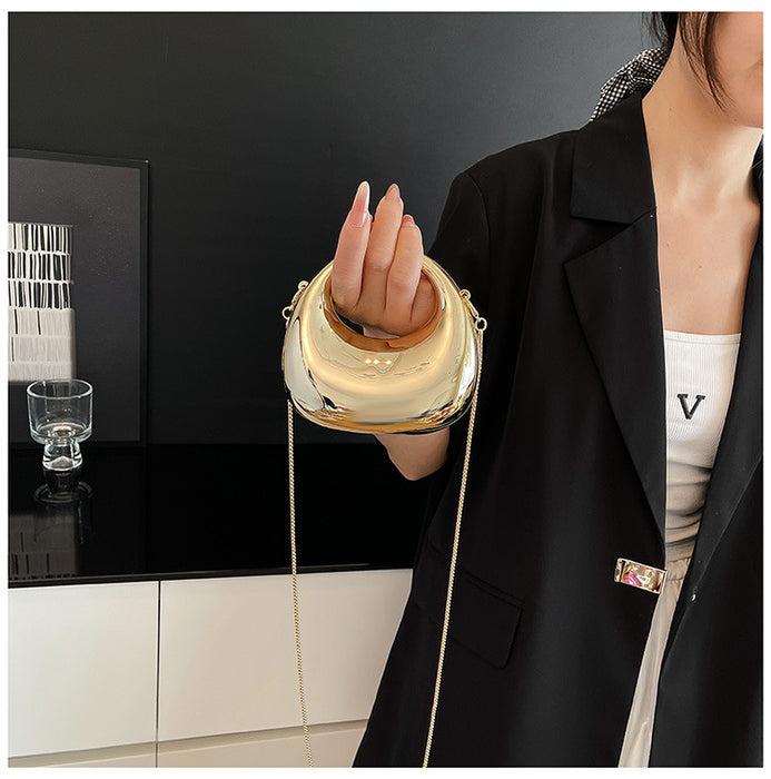 Person holding a gold handbag in an indoor setting