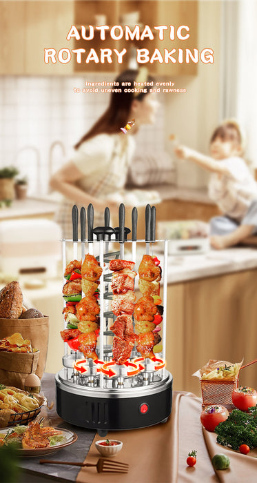 An automatic rotary baking electric grill with multiple vertical rotisserie skewers, shown in a kitchen setting with a blurred background of a woman and child cooking. The product features a black base, clear upper chamber, and black handles.