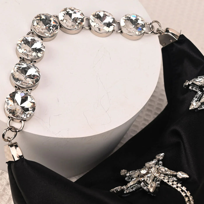 Elegant black necklace with crystal embellishments on a white background