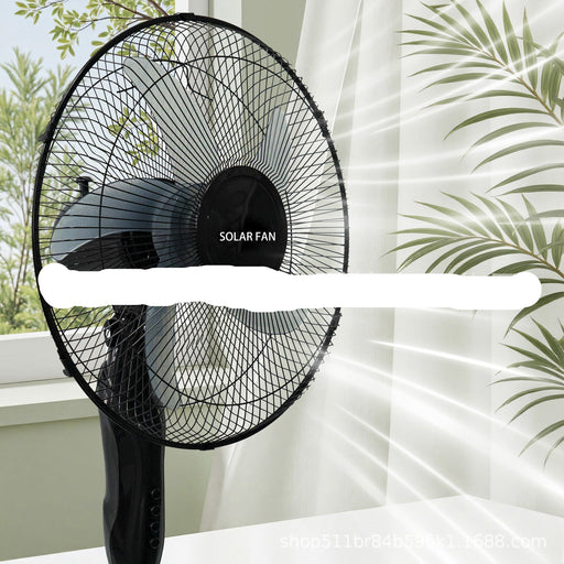 Black solar fan on a white surface with greenery in the background
