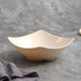 Beige ceramic bowl with dimensions on a gray surface