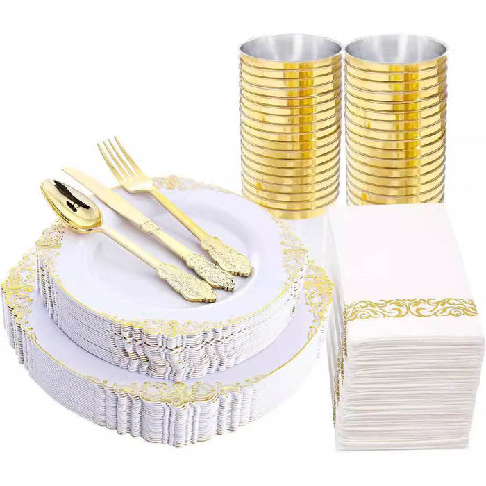 Gold and white party supplies including plates, cutlery, cups, and napkins on a white background.