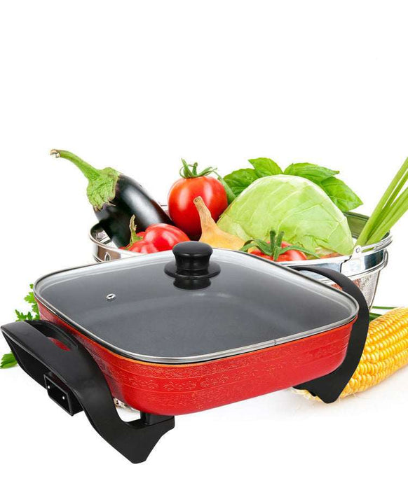 Red electric hot pot with vegetables on a white background